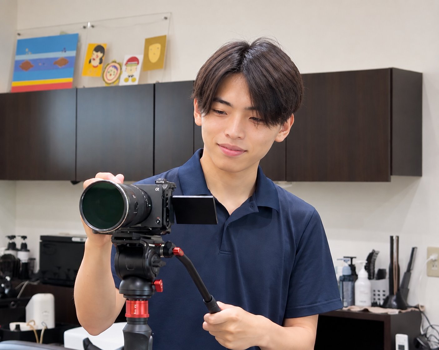 撮影の現場で三脚のカメラを構える株式会社ネクシス代表・東元龍希